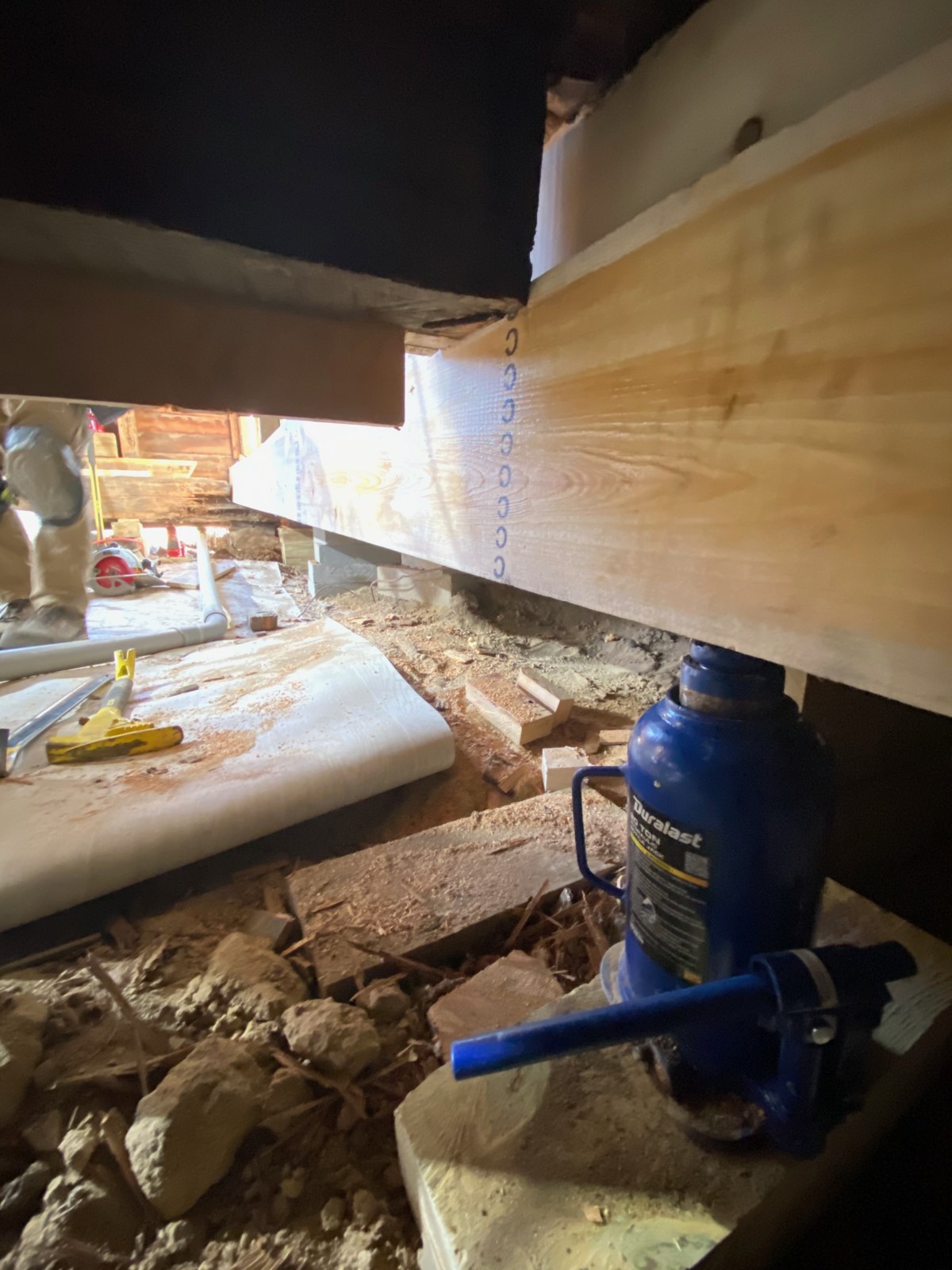 The new drop girder going in under the living room, lifted into place on bottle jacks