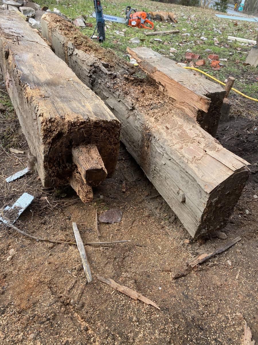 Old sill timbers set aside. The hollow one was carrying a corner of the house