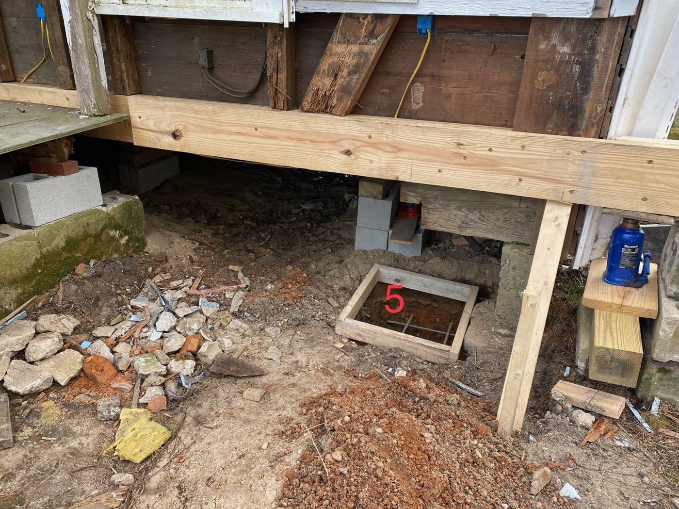 Footing number five with temporary framing still holding the corner of the house in the air until we can get the new foundation finished. The jack stays until t
