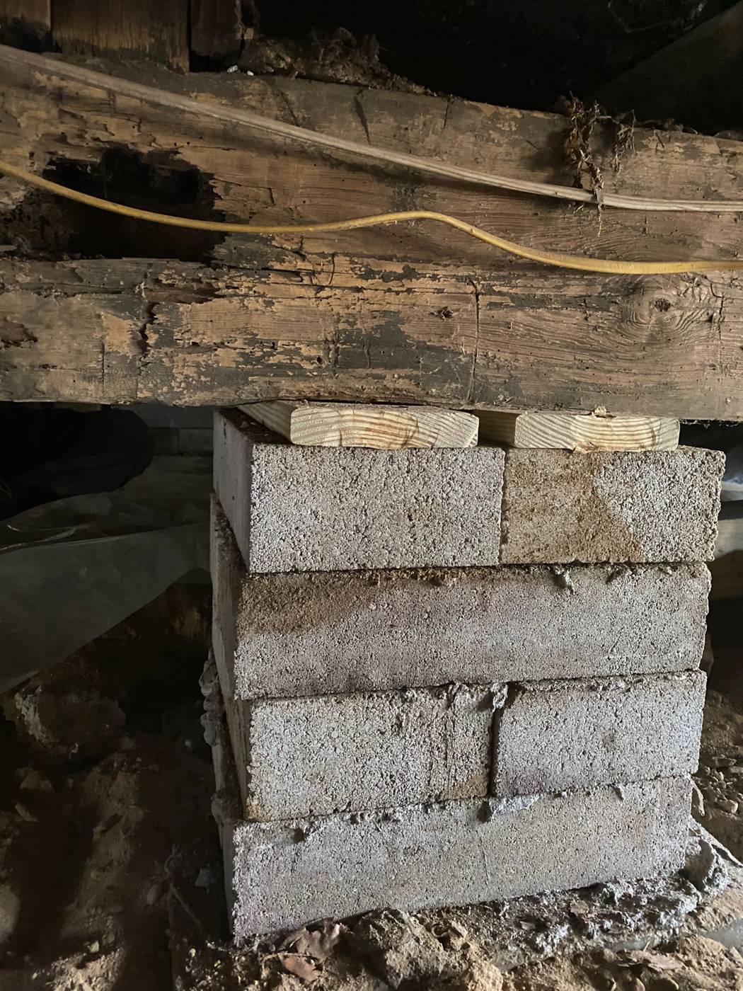 A block pier replacing stacked stone under a hand-hewn girder