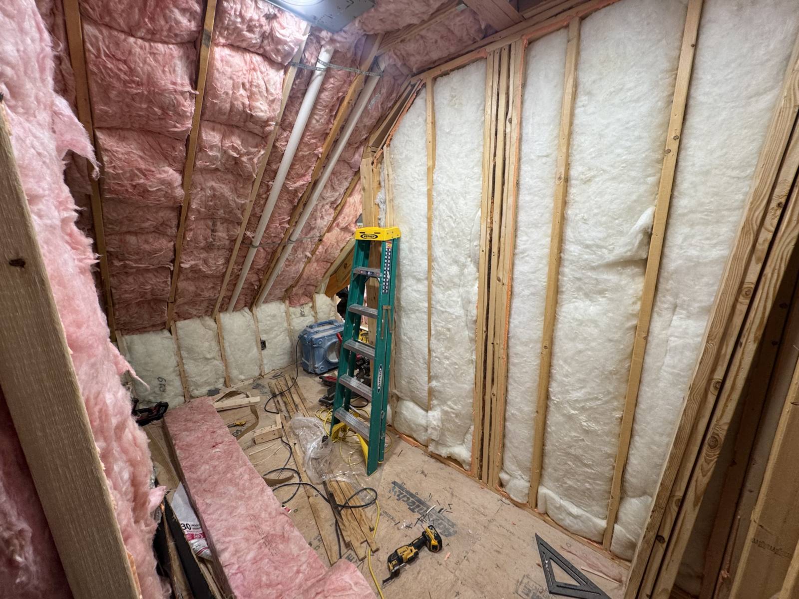 Attic framed and insulated: pink batts in the roofline and white batts in the new knee walls, drywall not yet hung