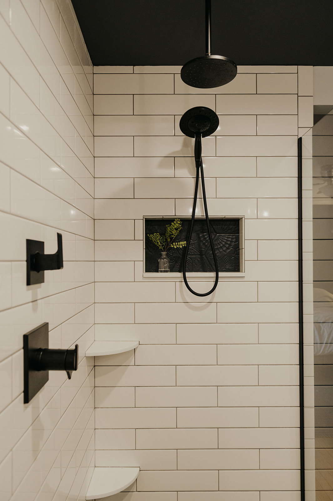 After: zero-entry walk-in shower with subway tile, matte black fixtures, and dual shower heads