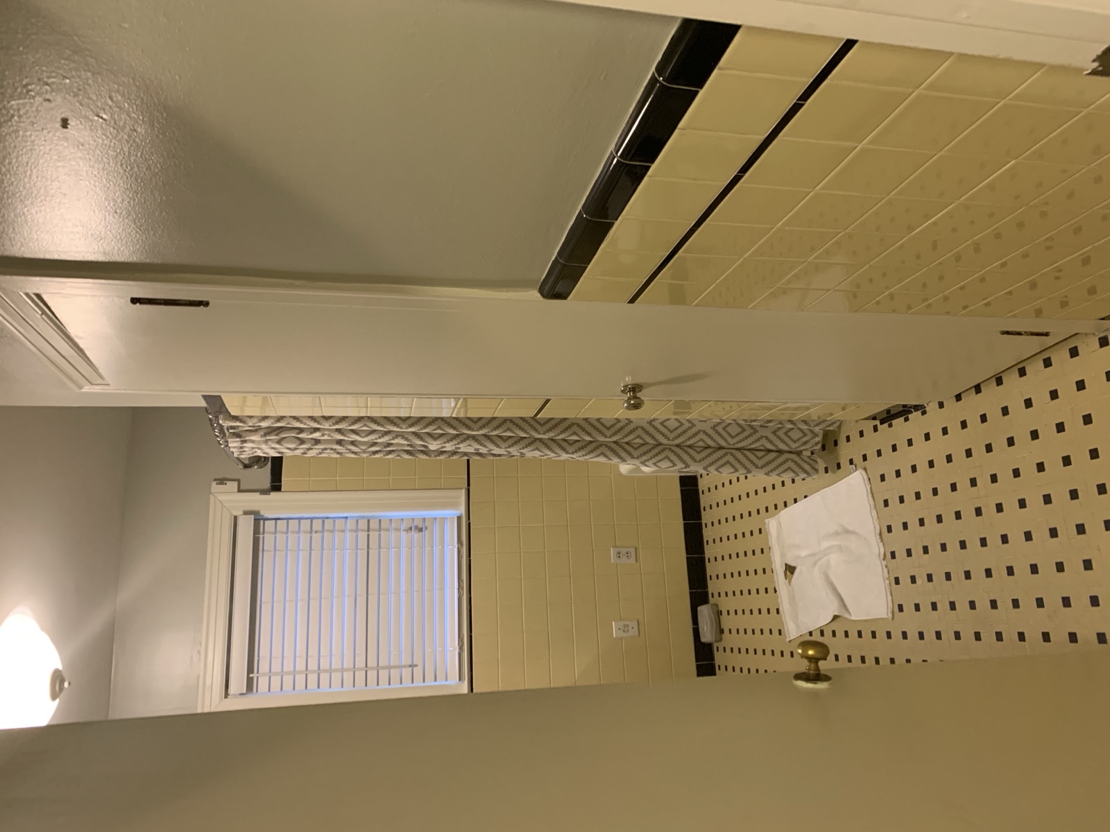 Before: yellow 4x4 wall tile and black-trimmed checkerboard floor in the 1950s Southern Pines primary bath